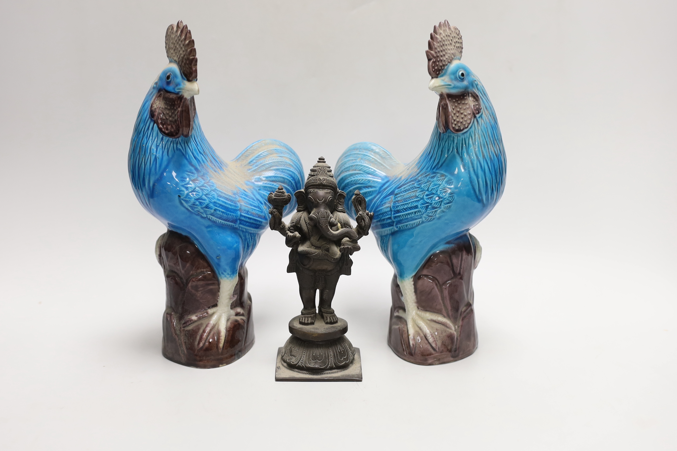 A pair of Chinese export polychrome models of cockerels, 25cm, and a small export cast bronze figure of Ganesh (3)